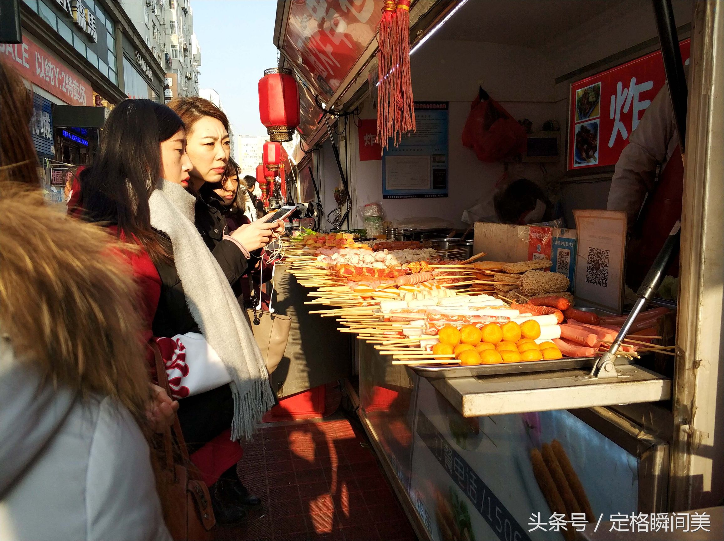 图为:台东步行街上,一烤肠小吃摊位上,挤满了前来购买美食的顾客.