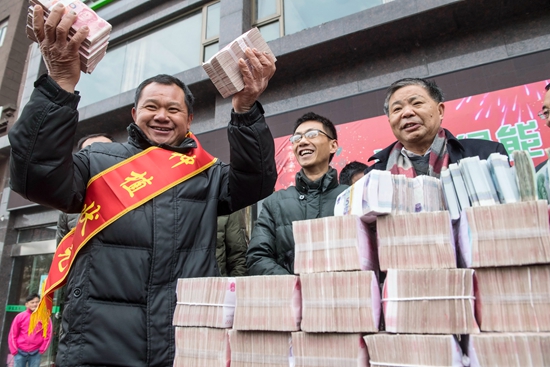 1月8日,个人奖金最高的刘高美左手拿着近20万元的奖金向大家致意.