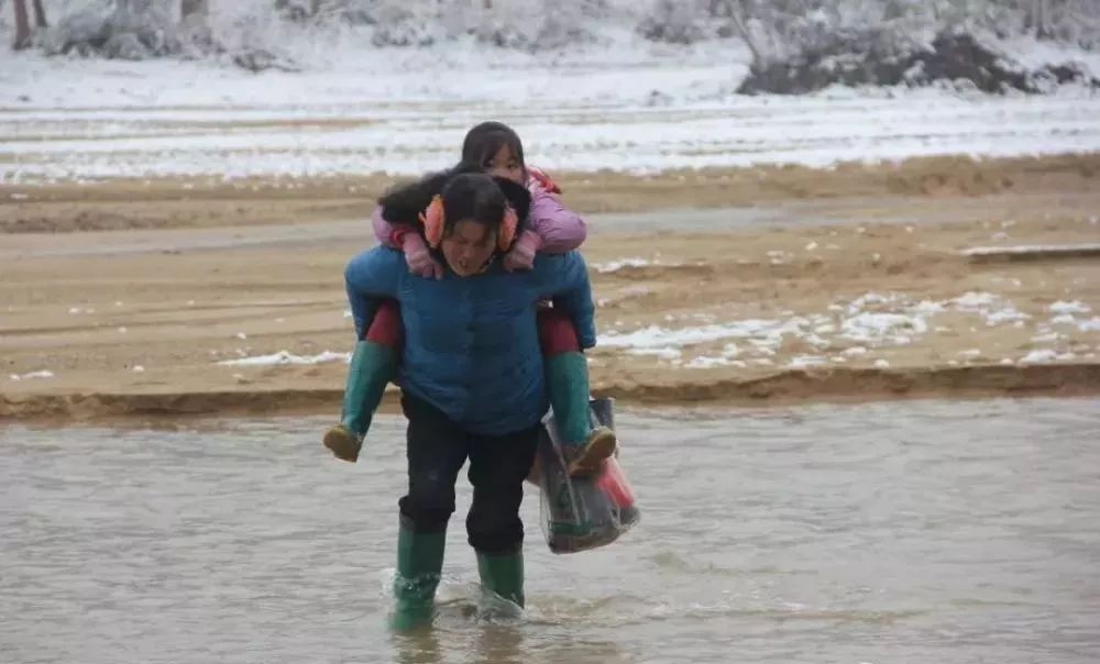 只能背着孩子过河不敢过竹桥的母亲变得更加难走加上下雪后结冰桥本身