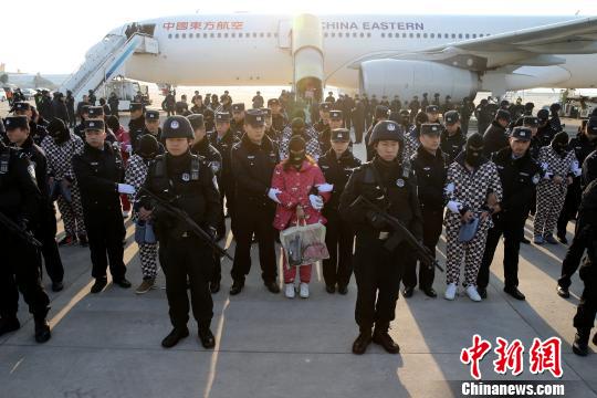 图为嫌疑犯被押解下飞机 张远 摄