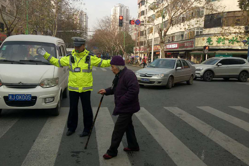 常德交警直属二大队:执勤民警爱心满满护送老人过马路