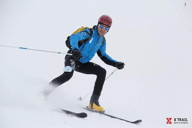 比赛中,选手背负滑雪板徒步登山