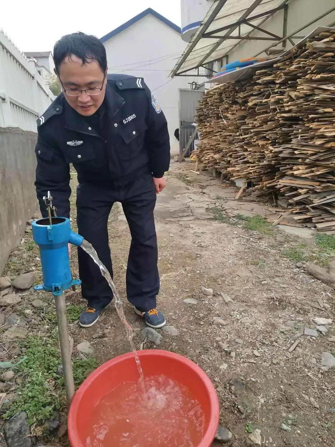 广德县公安局柏垫派出所辅警正在压水井打水