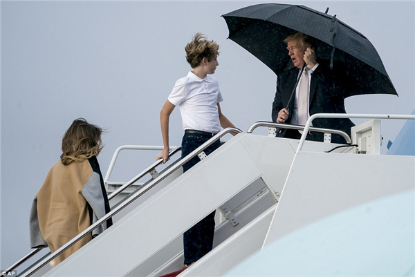 特朗普撑伞前面走妻儿淋雨跟在后 外媒:太不绅士!