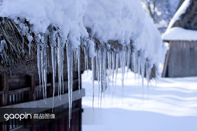 雪地里,房檐上厚厚的雪和冰挂.