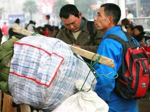 2名打工者在苏州火车站广场候车 虽大包小包很是辛苦 但眼神里满是