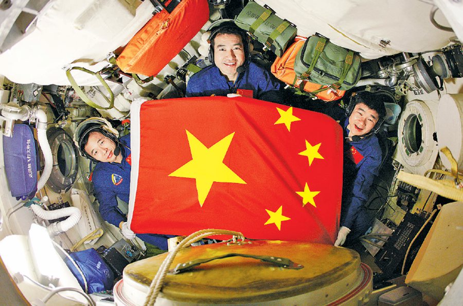 航天员翟志刚,刘伯明和景海鹏在飞船内展示五星红旗. 朱九通摄