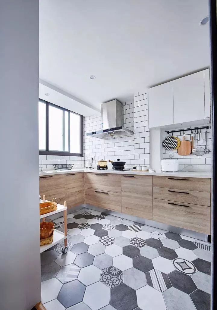 厨房地面通铺六边形花砖,墙面采用白色瓷砖工字铺贴,木色地柜搭配