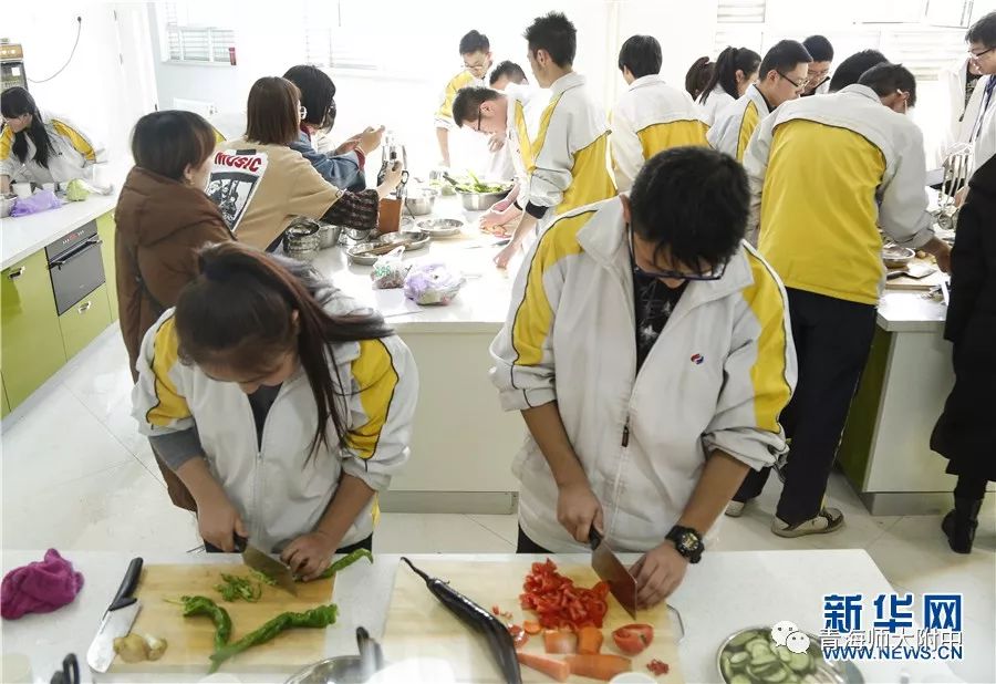 1月21日,在厨艺教室里,两名学生正在切菜.