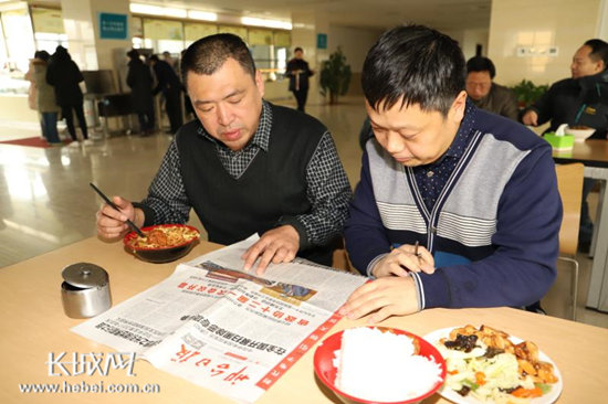 张利科图右和同事在医院食堂关注两会消息.董克强 供图