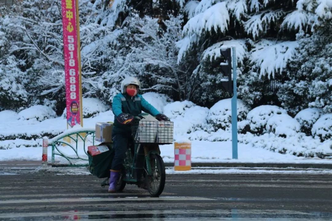 邮政快递派件员依旧坚守岗位,冒着风雪投送快件.