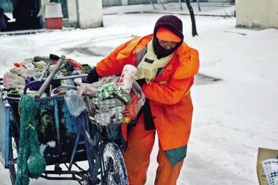 道路两旁的积雪成冰 但是穿梭在城区大街小巷的环卫工人 却依然没有停