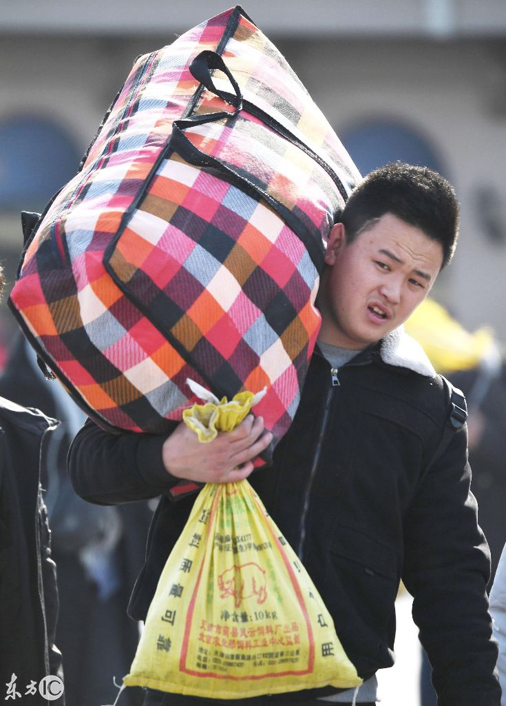 一个背着大袋子的男人走向北京站 (图片来自东方ic)