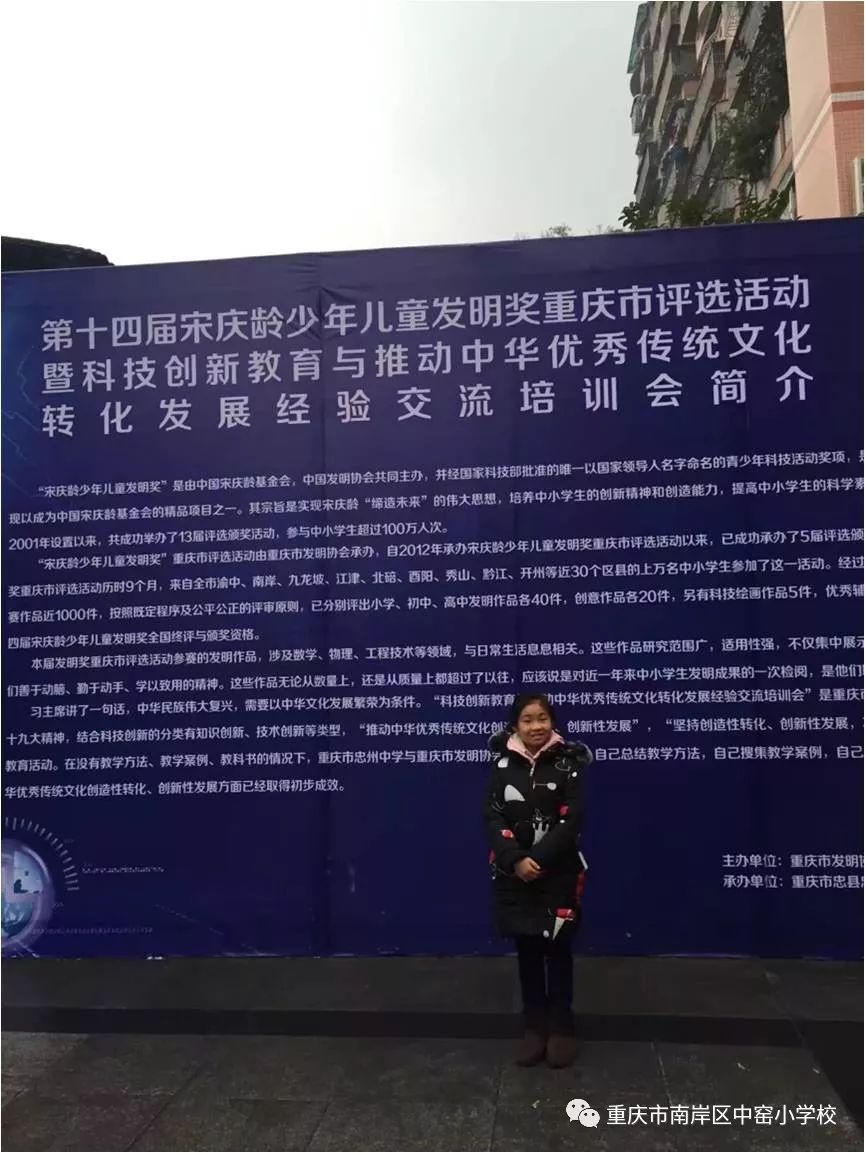 张雁羞同学在第十四届宋庆龄少年儿童发明奖展评活动展板前留影.