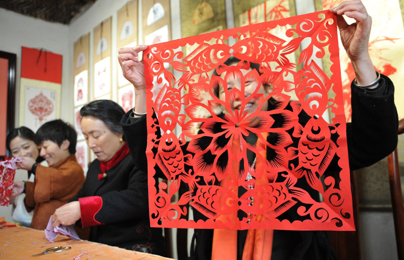 2月2日,在河北省黄骅市东常庄剪纸风情艺术小镇,一位村民在展示剪纸