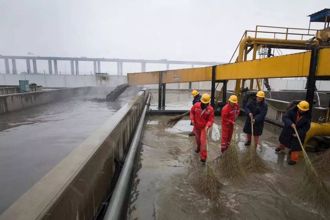 1月27日,泥浆沉淀池旁,工人们在清扫融化的雪水.