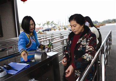 2月11日,永安镇人严婷左一正在川南大草原检票口欢迎游客