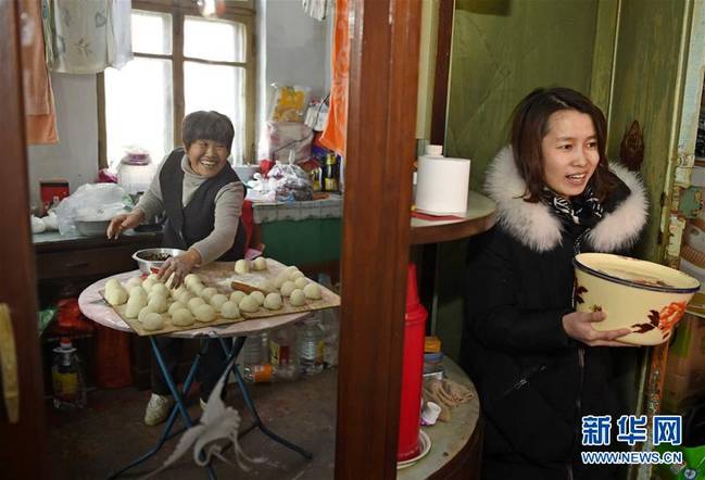 2月13日,沈阳市铁西区工人村的刘惠明(左)与邻居一同制作豆沙包.