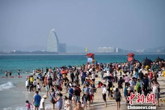 资料图:进入旅游旺季以来,三亚的各大景区海滩每日"挤"满游客.