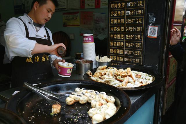 2月21日,大年初六,市民在济南芙蓉街品尝美食小吃.