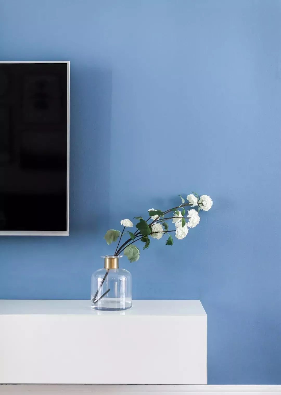 蓝色电视背景墙,白色电视柜,呈现简约氛围.