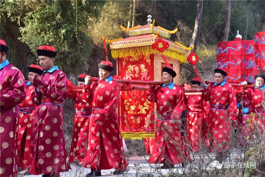 25日上午九点,新娘身披红嫁衣,头戴凤冠,坐着大花轿,迎亲牌子举起来