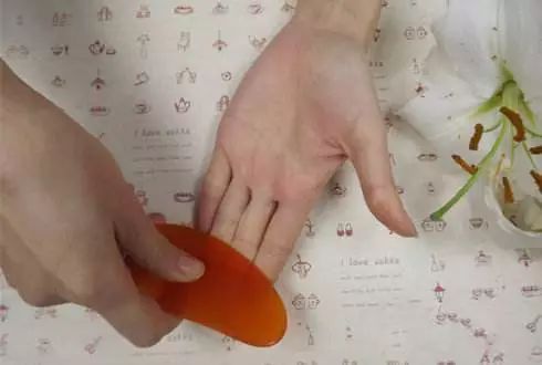 可用刮痧板的面刮拭手掌,手掌发热后用刮痧板上的凹槽刮拭手指的四面