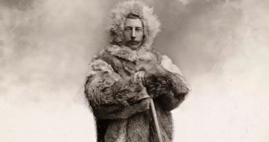 阿蒙森身披因纽特式的狼皮大氅,在挪威离家不远处的雪地中拄杖远眺.