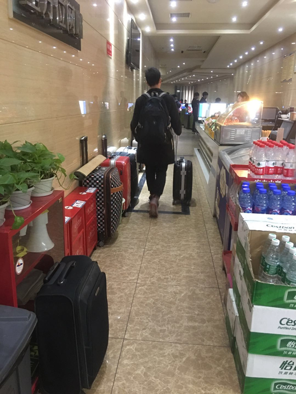 其中,有一个男生背着书包,拖着行李箱,正在网管处排队办理上网手续.