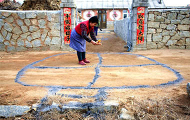 然后在院子里用草木灰画圆圈,中间放五谷和钱币,象征粮囤,以祈