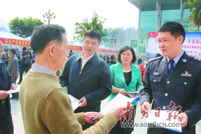 阳山县领导廖敬华,朱燕群,黄构恩为群众派发宣传单张.段灿 卢志满 摄