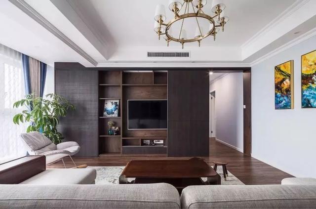 客厅电视墙的造型与收纳功能组合一体,壁挂电视机搭配木色的收纳