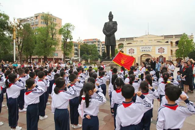 大元帅府小学少先队员在孙中山戎装像前集合,出队旗