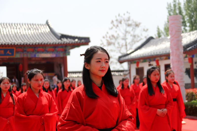 河南永城芒砀山旅游区夫子山孔子像前,数十名女子身着汉服重新按照