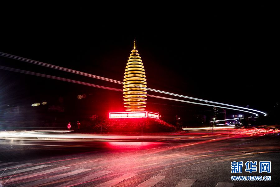 夜幕中容城县地标建筑容和塔,大车车顶灯驶向奥威路后,在夜空留下一道