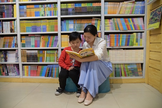 一位妈妈带着孩子在书店阅读图书