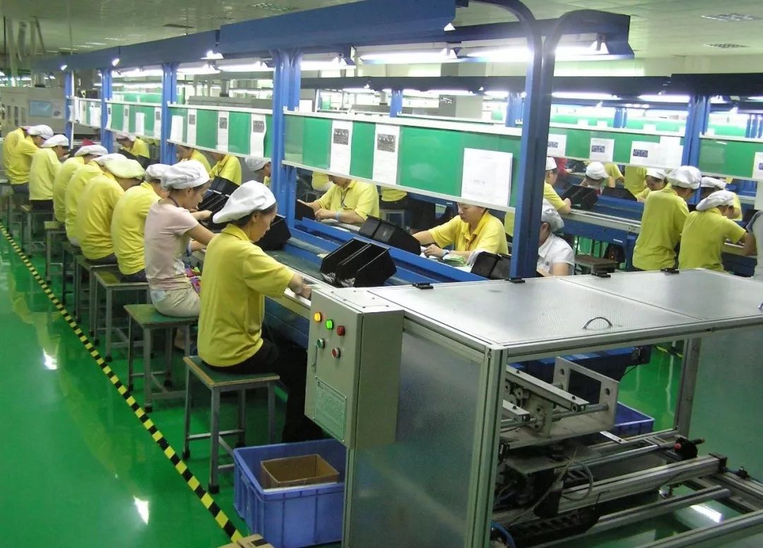 工人们在电子元件生产流水线上工作