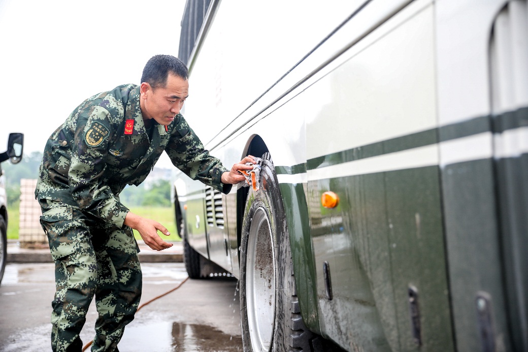 武警重庆总队机动支队运输修理中队驾驶员兼修理工周志诚在清洗车辆.