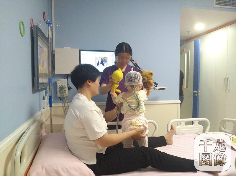 图为东区儿童医院患儿正佩戴脑电监测系统的设备.