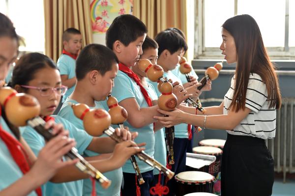 5月17日,阳曲县首邑学校的学生在课堂上学习吹奏葫芦丝.