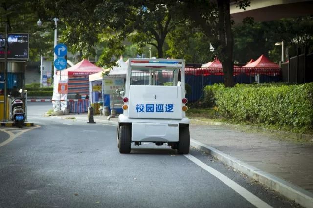 保安正开着校园巡逻车围绕校园巡逻.