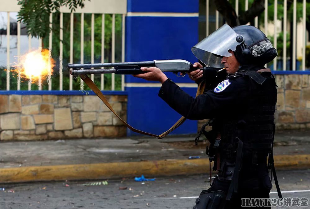 5月28日,一名防暴警察手持霰弹枪向参加反政府抗议的大学生射击.
