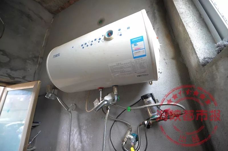 卫生间内安装了一台储水式热水器,热水器下方还有一个增压泵