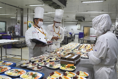 如今的配餐间里,厨师长在检查餐食.