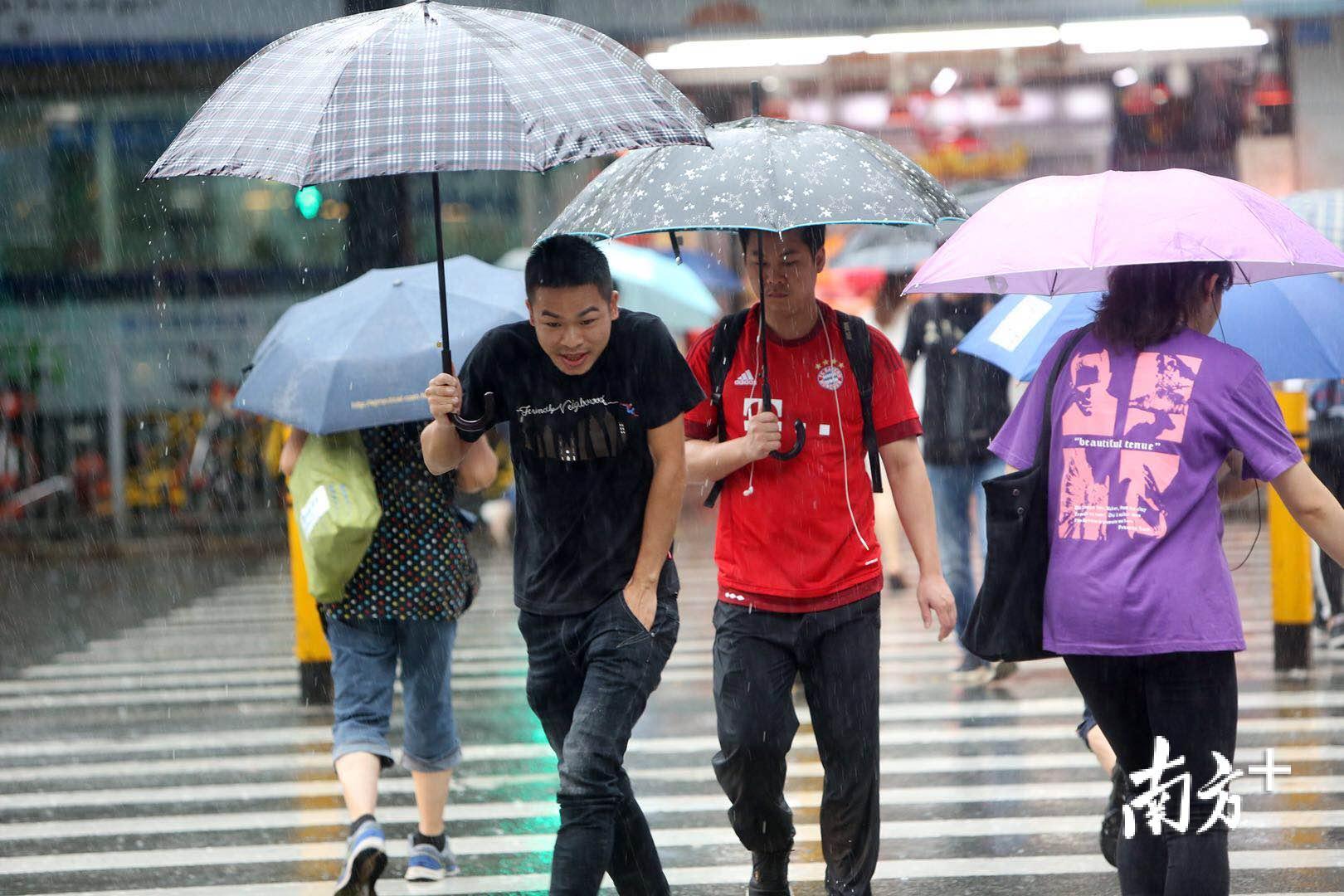 深圳暴雨红色分区预警,雨中行人步履匆匆