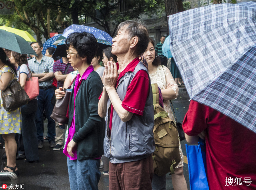 高考第二日 家长冒雨考场外守候 祈祷孩子考试顺利