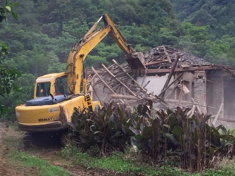 在安基山林场,挖掘机对危旧土坯房进行拆除作业.