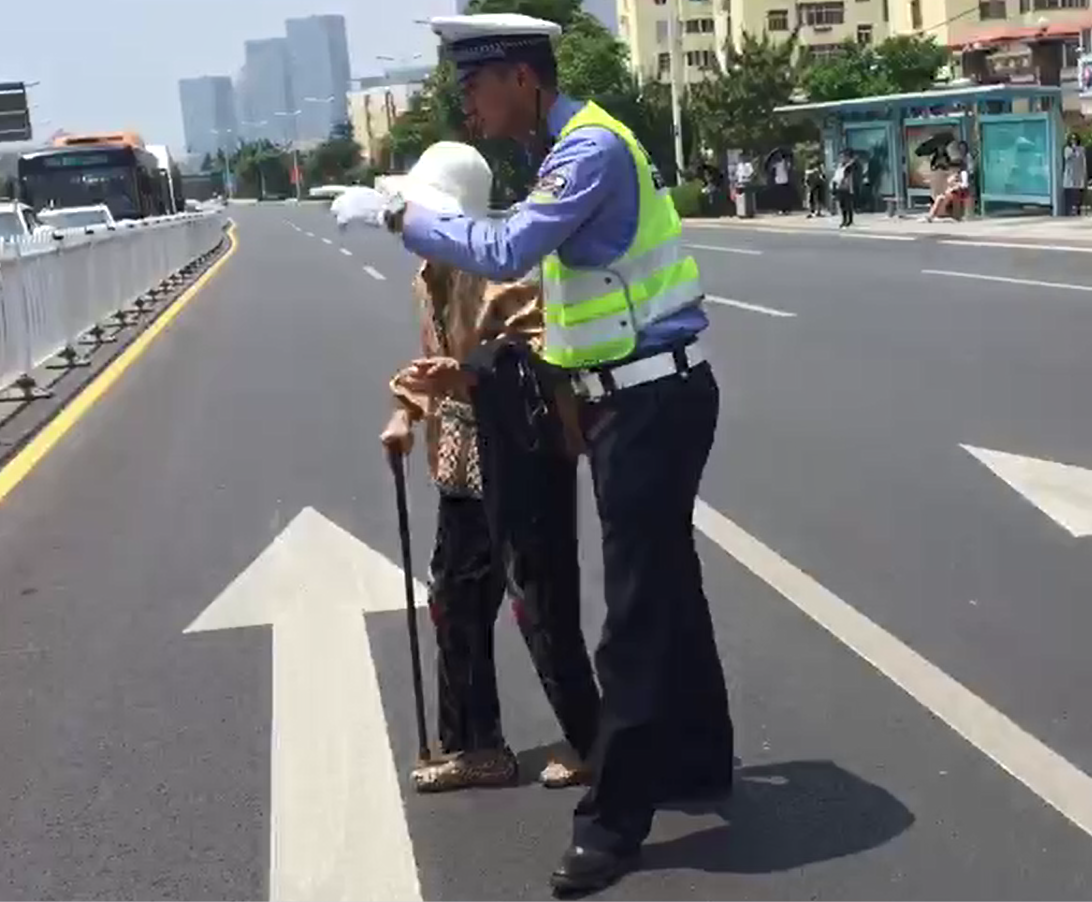 崂山交警扶行动不便老人过马路 过往车辆一起礼让