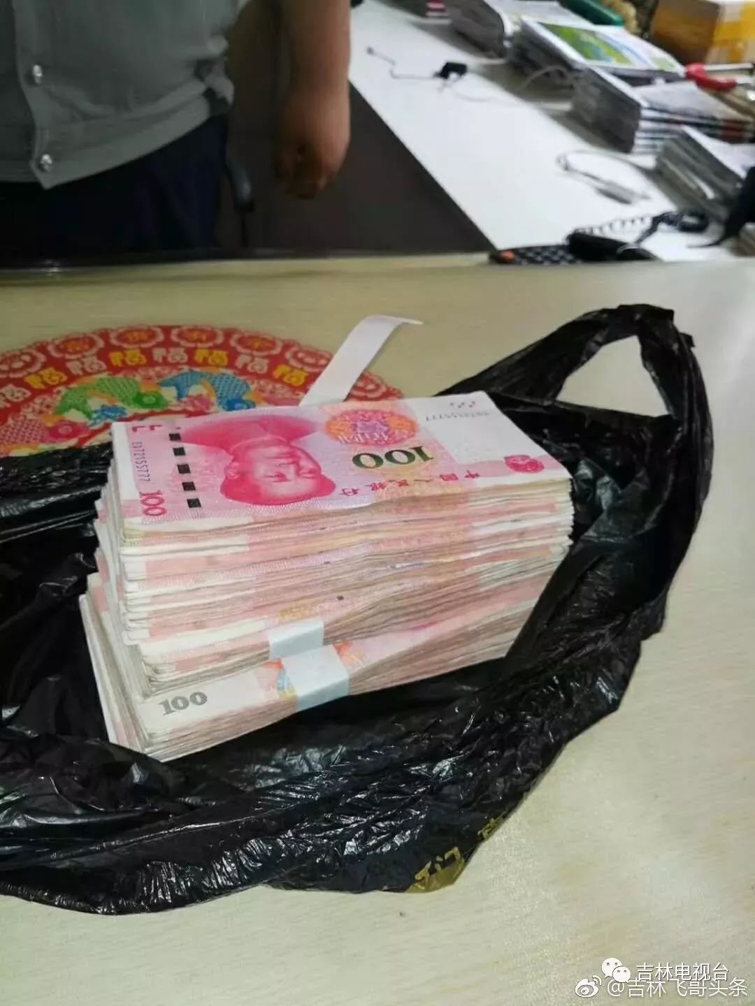 发现了这个塑料袋, 他打开之后发现是一摞百元现金,就赶紧将这个袋子