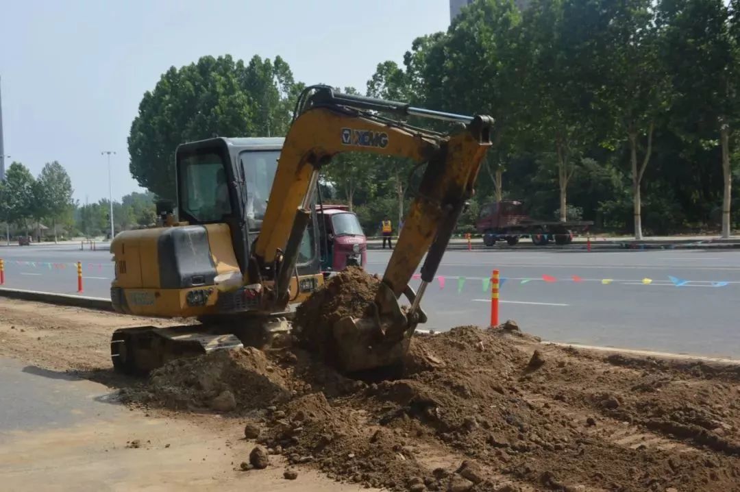 6月7日,一辆挖掘机正在拆除绿化带.